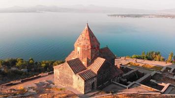 vista aérea complejo del monasterio armenio sevanavank en la ciudad de sevan con panorama del lago azul al amanecer. turismo famoso en el cáucaso. concepto de viaje armenia video