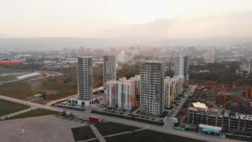 panorama de edificios de bloques inmobiliarios con sol cubierto sobre el horizonte con fondo de cielo nebuloso video