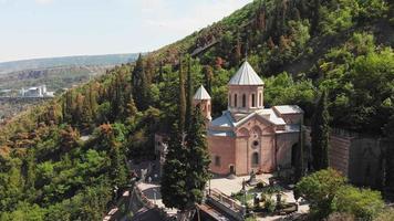 stigande flygvy st. davids kyrka som heter mama daviti på sluttningen av berget mtatsminda. mtatsminda pantheon av författare och offentliga personer ligger runt st. davids kyrka video