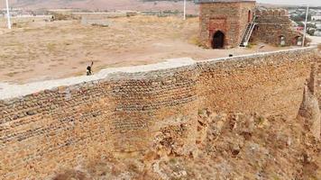 turista feminina tomando selfie no topo do castelo com vista panorâmica da cidade de gori. aventura de viagem em más condições meteorológicas video