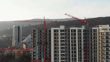 Aerial close up view one crane moving right with building and sky background video