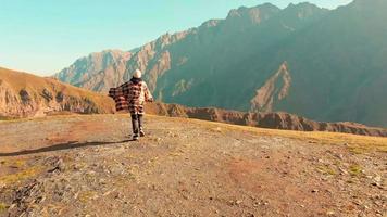 une femme de race blanche se tient avec une couverture et aime la montagne dans la solitude video