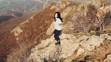 Young beautiful woman dance close up in nature alone with beautiful landscape panorama background. Exciting travel in caucasus