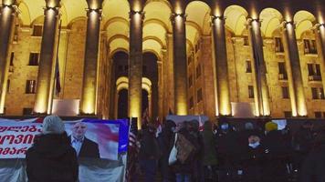 Tbilisi, Geórgia, 2021 - aniversário de cem anos - evento de protesto em Tbilisi. nika melia cartaz gigante em exposição com fundo do parlamento. video