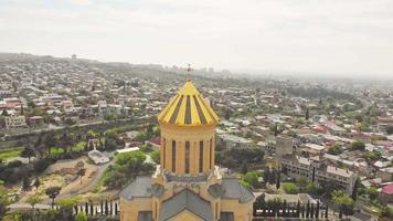 Aerial close up view of golden dome of Holy trinity cathedral. Georgian orthodox style churches video