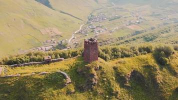 Aerial circle around historical Ushguli castle fortification ruins up the hill surrounded by scenic green nature. Upper svaneti sightseeing objects video