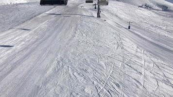 panoramisch uitzicht vanaf stoeltjeslift naar beneden naar helling zonder mensen en lege stoeltjesliften. skivakantie in gudauri, georgië video