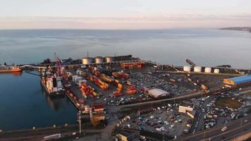 Aerial view loaded cargo ship with freight containers docked by Batumi international seaport with black sea view on sunset
