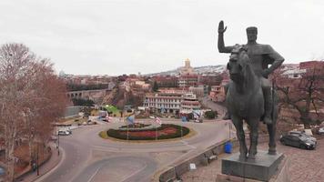 vista en tiempo real de la estatua gigante del rey con coloridos edificios arquitectónicos. destino de viaje de georgia - tbilisi video