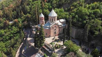 antenn tilt down view st. davids kyrka som heter mamadaviti på sluttningen av berget mtatsminda. mtatsminda pantheon av författare och offentliga personer ligger runt st. davids kyrka video