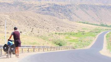 armenië, 2021 - mannelijke blanke gespierde fietser duwt fiets buiten in de bergen van Armenië video