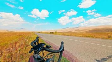 Static time-lapse bicycle on side of road with beautiful panorama views outdoors in sunny day. Cycling road trip and travel concept background video