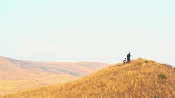Fit young caucasian male person push bicycle uphill with mountains background outdoors in caucasus mountains. Achievement , inspiration, challenge and determination concept