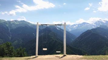 vista estática de las cabañas heshkili vacías en movimiento svaneti columpios en cámara lenta con fondo de montañas del cáucaso