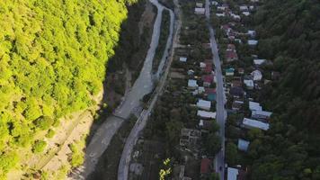 luchtfoto naar de rivier en traditionele Georgische huizen in het dorp Pasanauri. Georgisch cultuur- en levensstijlconcept video