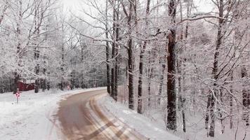 Winter road view in forest with hub standing on side road. Winter holidays in countryside caucasus