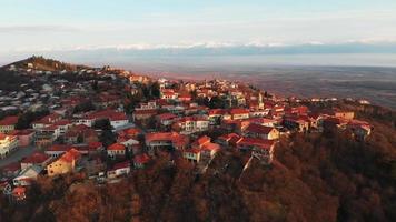 luchtfoto van sighnaghi stadsgebouwen in georgië met de achtergrond van de kaukasus-bergen in de herfst. beroemde reisbestemming georgië video
