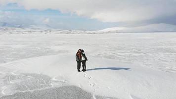 vista aérea mãe filho juntos posam selfie com bela paisagem de montanhas brancas de inverno.viagem conceito de alegria e felicidade video