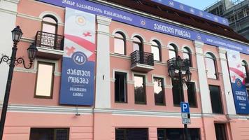 tbilisi, georgia, 2020 - vista inclinada hacia arriba hasta el edificio exterior de la fiesta de los soñadores con símbolos de agitación. video