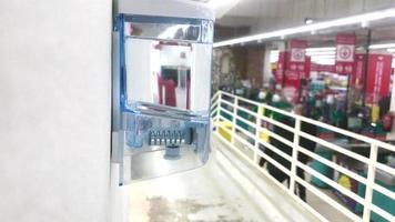 tbilisi, geórgia - 2020 - desinfetante em uma loja pronta para uso na entrada para pessoas usarem com clientes que passam e caixas ao fundo. higiene durante a quarentena e pandemia