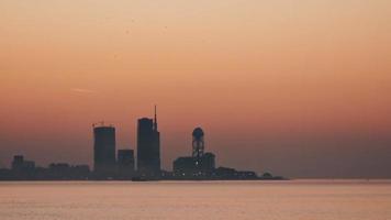 Nachtstadt Batumi Zeitraffer blaue Stunde mit Panorama am Wasser. Batumi, Adscharien, Georgien. Panorama der beleuchteten Kurstadt bei Sonnenuntergang. Schwarzes Meer, Riesenrad und Alphabetturm video