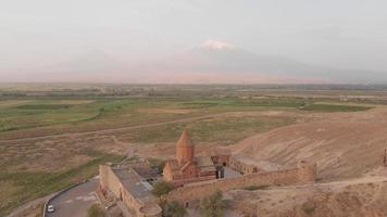 Vue aérienne du cercle au ralenti autour d'un point de repère historique en arménie - monastère de khor virap avec fond de sommet de montagne ararat au lever du soleil