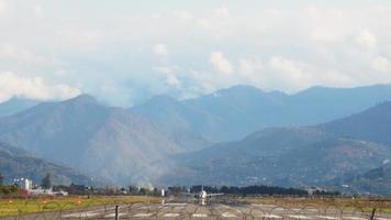 vista estática pista do aeroporto batumi com partida de avião comercial em tempo real e fundo das montanhas do cáucaso video