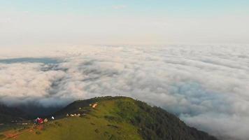 luftaufnahme hinunter zu holzhauskonstruktionen auf den gomis-bergen über malerischen wolken. Immobilienentwicklung in landschaftlich reizvollen Lagen