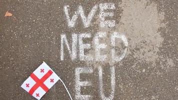 Georgian flag lay on ground by written statement We need EU. Integration process to EU concept video