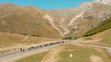 Aerial ascending view of group of mountaineers going towards Kazbek mountain in background video