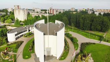 bela e moderna igreja siauliai na parte sul da cidade da perspectiva aérea. edifícios da cidade no fundo. video