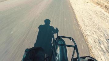 vista de roda de hiper lapso de movimento rápido com silhueta de homem andando de bicicleta em fundo de asfalto ao ar livre video