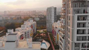 tbilisi, georgia - 17 de octubre de 2021 - panorama de edificios complejos de apartamentos de diamantes verdes con fondo soleado de puesta de sol. concepto de industria de negocios de propiedad inmobiliaria de georgia video