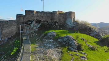 Aufsteigende Aussicht aus der Luft Kveshi-Festung mit Weg und Kreuz an der Spitze. historisches und kulturelles erbe in georgia. video