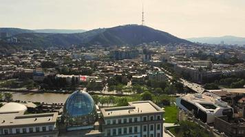 Flygfoto över presidentpalatsets byggnad med flagga på toppen och Tbilisi stadscentrum Visa bakgrund video