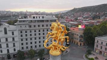 Tbilisi, Georgia, 2020 - Aerial city panorama with St.George golden statue close up in liberty square.