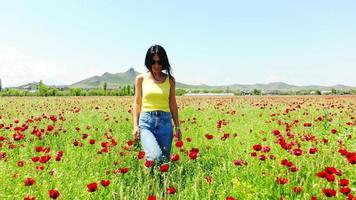 Front view young brunette caucasian pretty woman happy walk in poppy field enjoy spring in countryside of Georgia, Caucasus