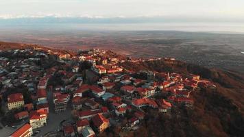 Aerial view of Sighnaghi city buildings in Georgia with caucasus mountains background in autumn.Famous travel destination Georgia video