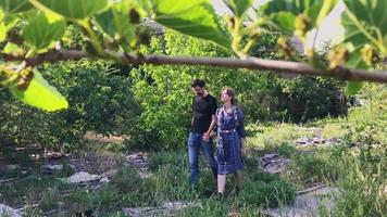 casal caucasiano anda em volta do lixo e da natureza verde poluída do verão. lixo no fundo conceitual da terra video