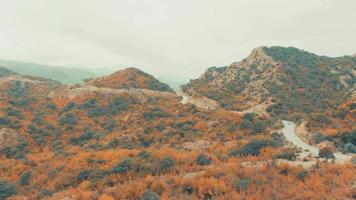 Vista aerea della strada nelle montagne del Caucaso con auto di passaggio con sfondo panoramico del paesaggio autunnale.turismo e georgia di viaggio video