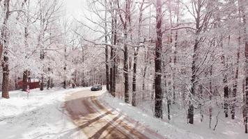 Tracking front view blue car slowly turning in narrow road in Sabaduri forest in winter video