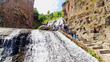 jermuk, armenien, 2021 - tourist klettert die treppe im freien durch den malerischen wasserfall wahrzeichen im freien. posieren für social media und tourismuskonzept