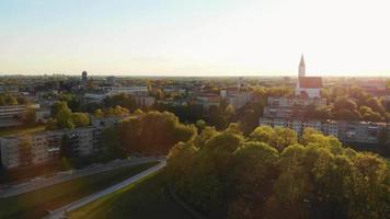 Beautiful panoramic aerial 4K video flying drone above sun city Siauliai panorama in Lithuania. Sunset cinematic Europe destinations