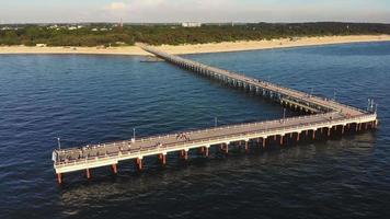 Aerial view pedestrians walking on Palanga pier bridge - famous landmark in summer. Lithuania holiday vacation. video