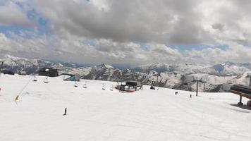 Tracking aerial view beginner female skiers skiing down hill on blue slope in Gudauri ski resort. Travel holiday destination. video