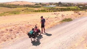 Luftrundblick fit kaukasischer männlicher Radfahrer auf Nebenstraße mit Smartphone für soziale Medien verbinden sich im Freien auf dem Land video