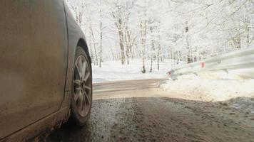 Low Angle View Reifen auf schlammiger, nasser Straße fahren schnell im schönen Wald. Straßenverhältnisse im Winter und Reifenhaftung