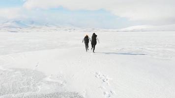 nahansicht mutter sohn dumm laufen zusammen gefrorenen see winterzeit mit erstaunlicher schneebedeckter berglandschaft. elternschaft und zusammengehörigkeit video