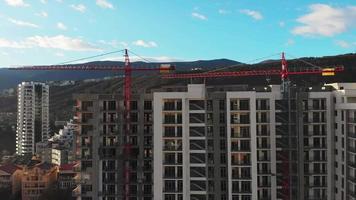 vista de cerca de dos grúas estáticas con nuevo edificio en construcción y fondo del cielo video