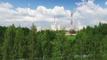 Ascending aerial view of Ignalina nuclear power plant area surounded by green nature in summer video